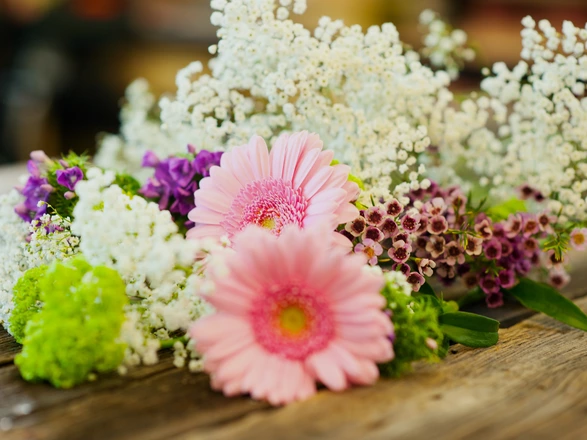 Nahaufnahme von einzelnen Blumen, die auf einem Tisch liegen.