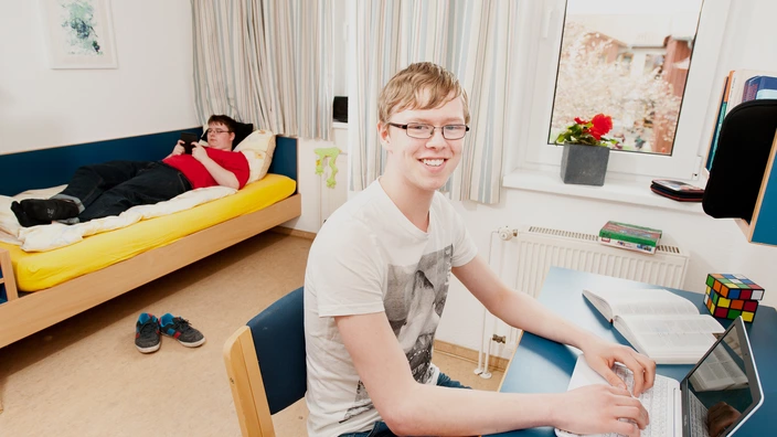 Zwei Auszubildende in einem Zimmer im Wohnbereich.