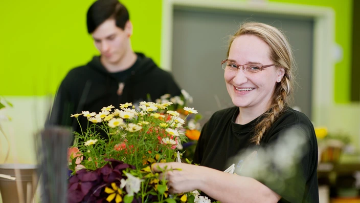 Zwei Auszubildende bei der Arbeit im Floristikbereich.