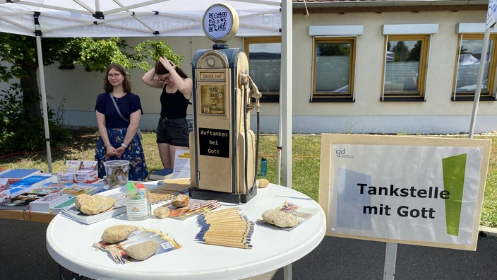 Zwei Personen am Stand "Tankstelle mit Gott"