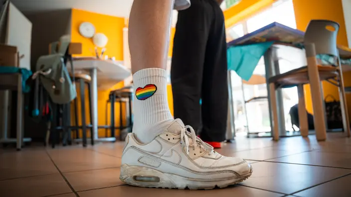 Workshopprojekt - Transzendenz: Detailaufnahme von weißen Sneakern und Tennissocken mit Regenbogenherz